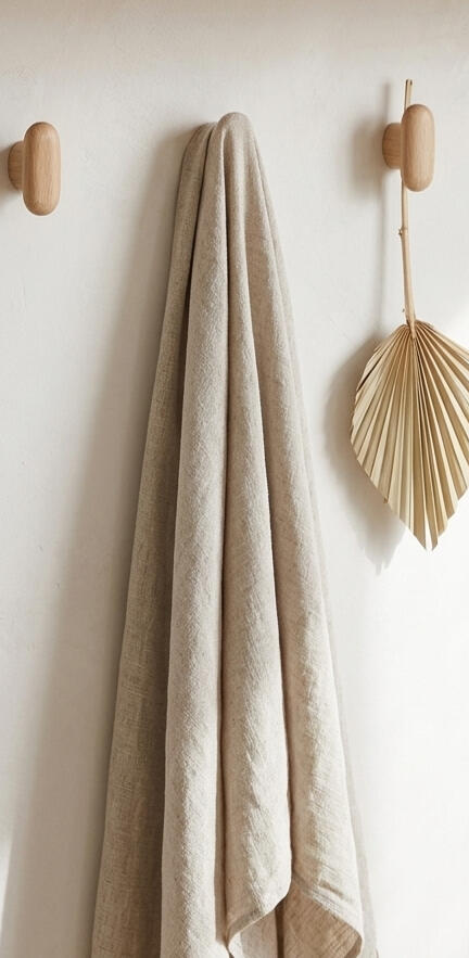 A neutral linen fabric hanging next to a dried palm leaf, creating a sense of natural tactile warmth